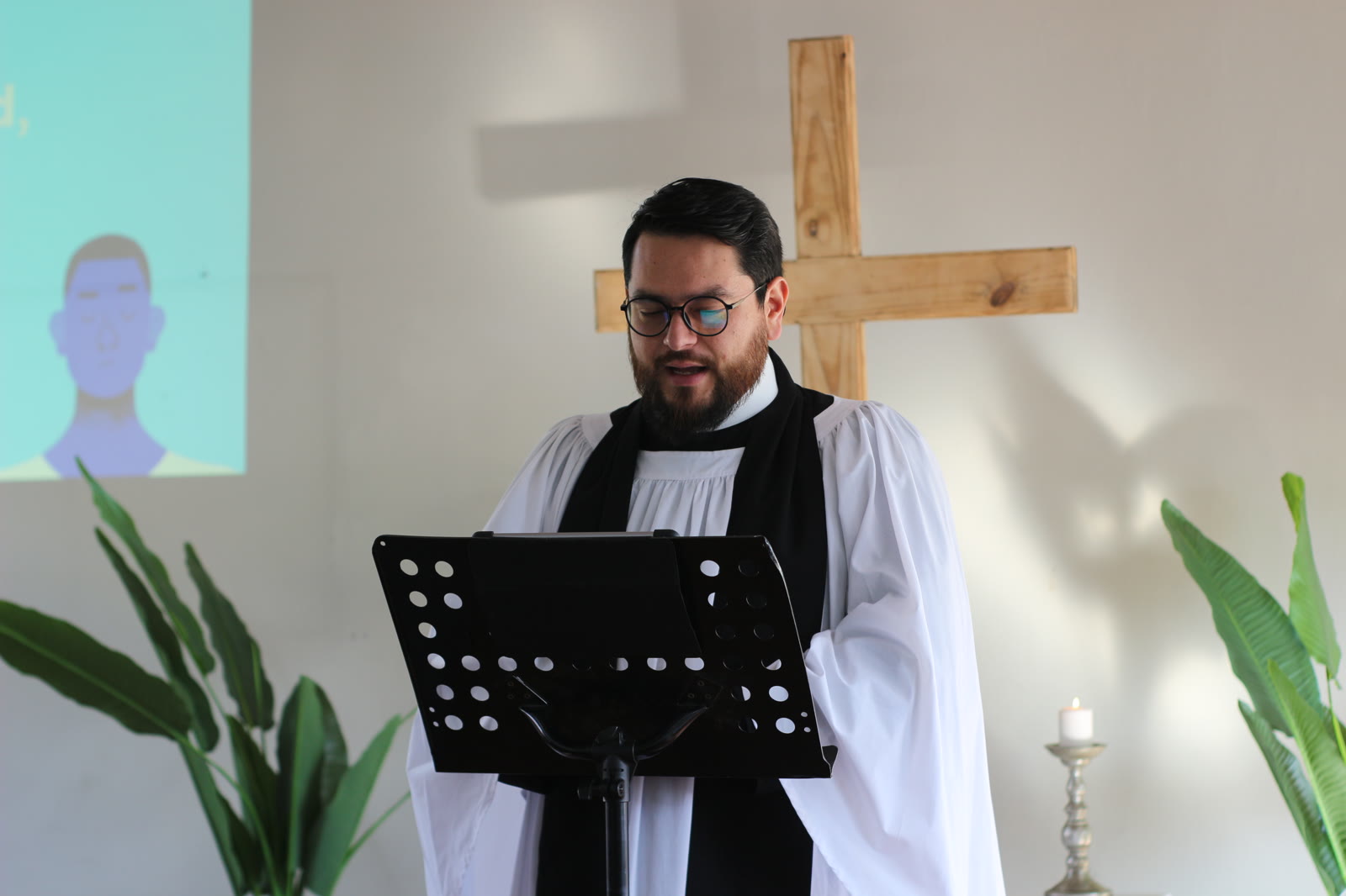 Pastor predicando con vestidura anglicana junto a la cruz